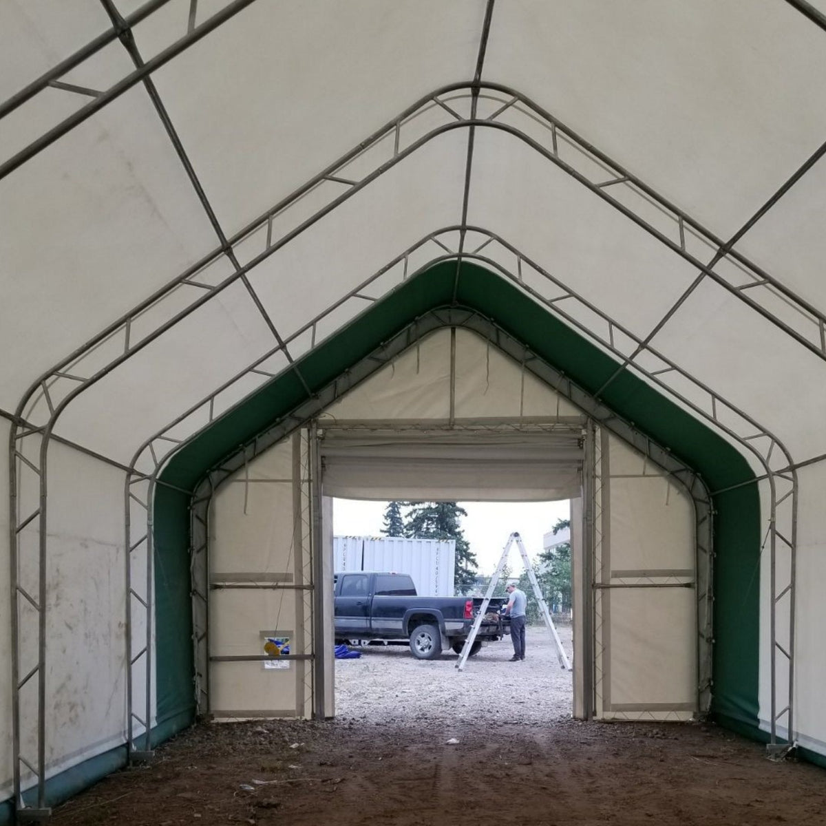 Interior view of Gold Mountain storage shelter with open green doors and gravel floor